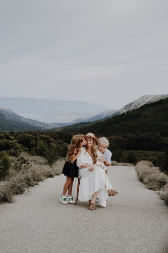 Profilbild Fotografin Jennifer Hartmann mit ihren Kindern Oskar & Olivia. Foto auf der Insel Krk mit Berg- und mehr Panorama in Farbe.